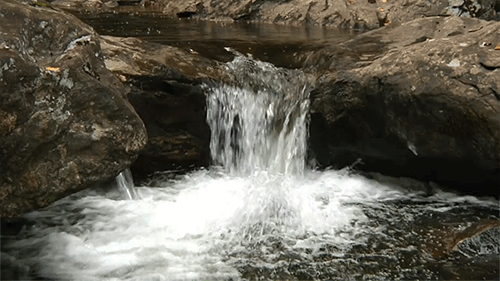 a stream of water calmly running through rocks forever